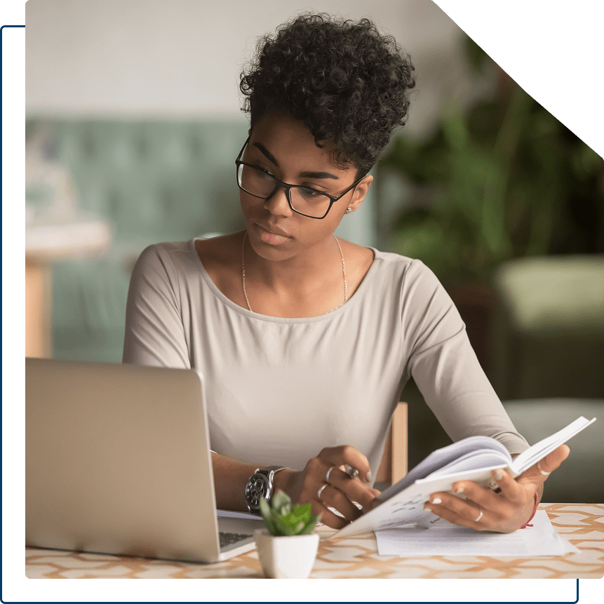 Woman studying with documents and laptop.