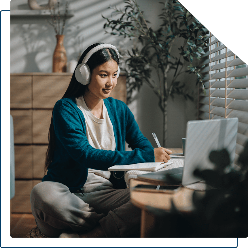 Woman studying at home with headphones on.